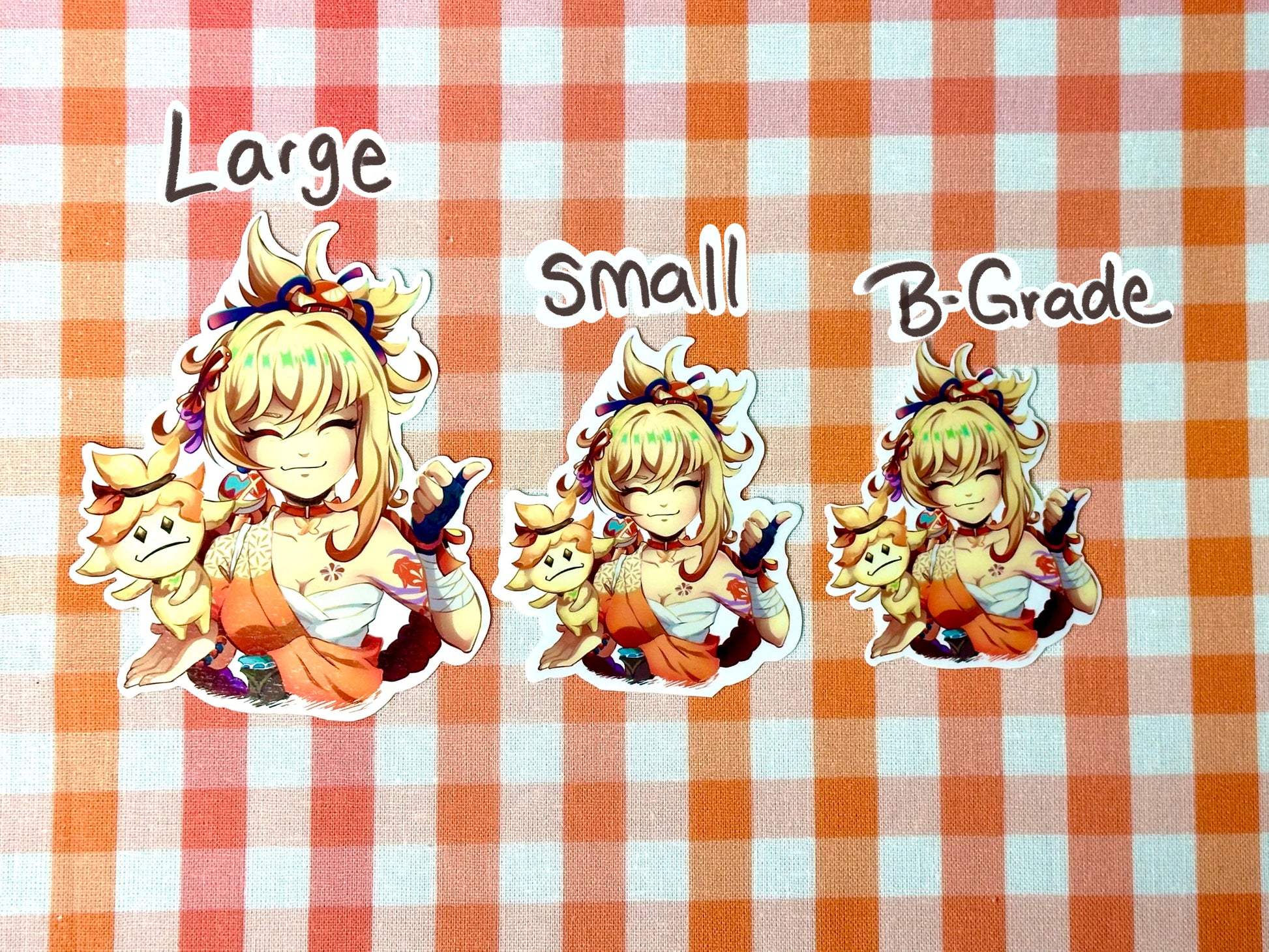 Different sizes of my Yoimiya emote sticker. Large, small, and B-grade. 