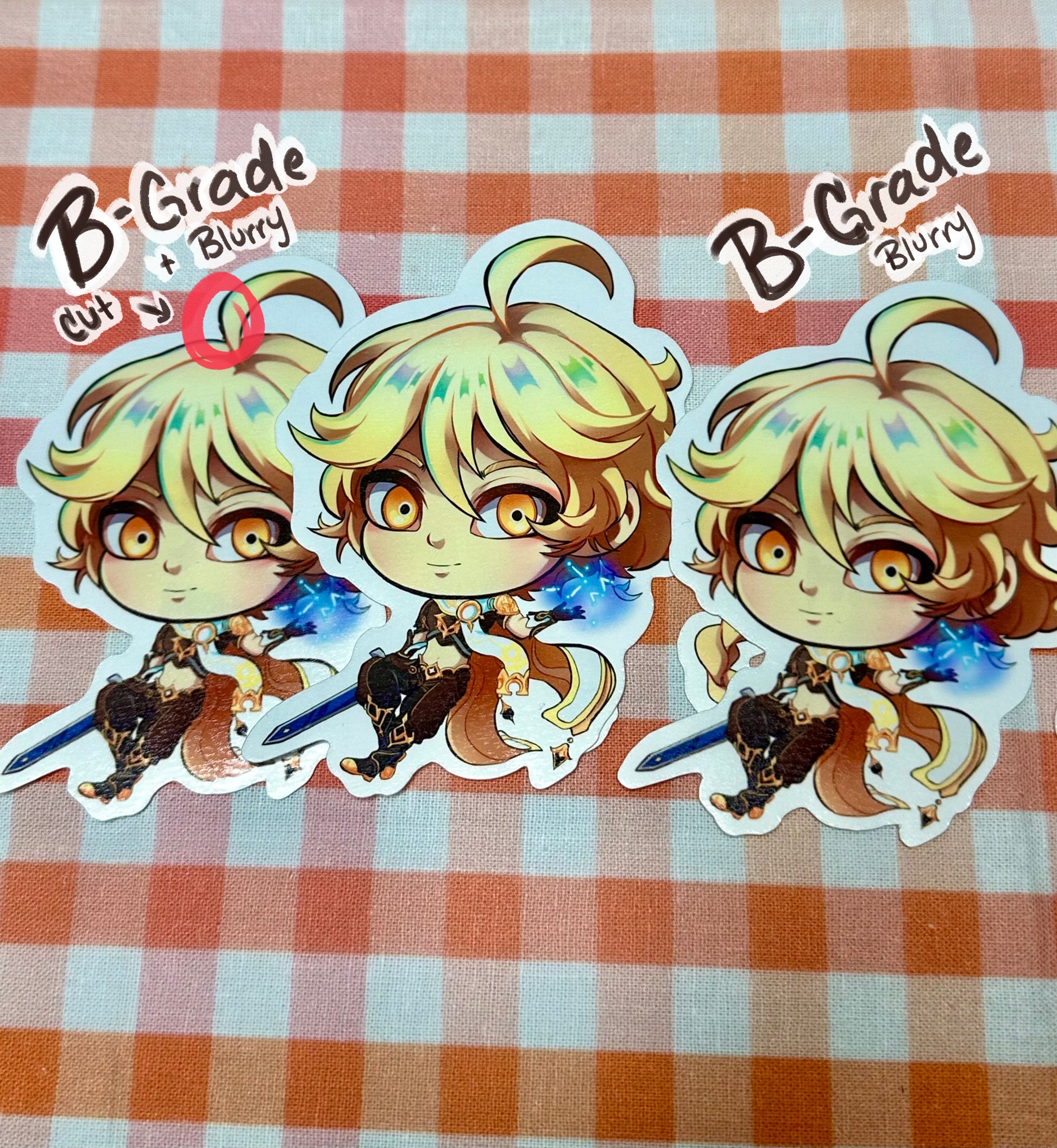 Different versions of B-grade chibi Aether stickers. One with a slight cut and blurry print. The other only blurry print. Both compared to a perfect condition Aether sticker.